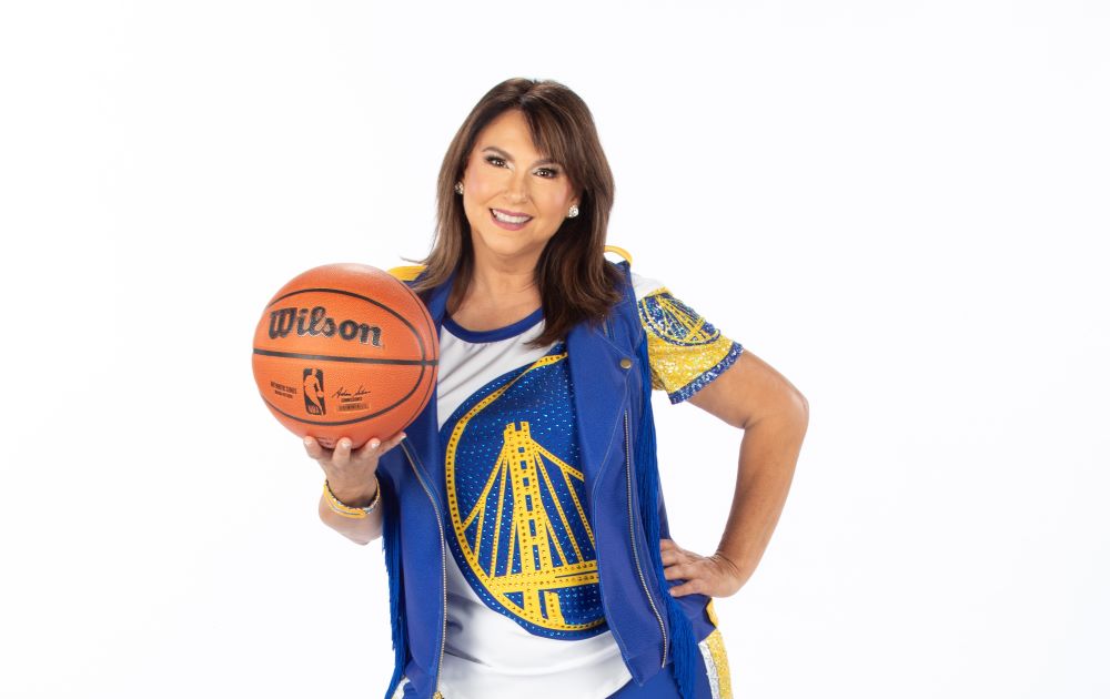 A photo of Liz Pimentel in her Golden State Warriors Hardwood Classics dance team uniform holding a basketball. 