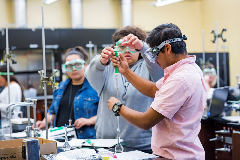 A photo of a students working in a chemistry laboratory. 