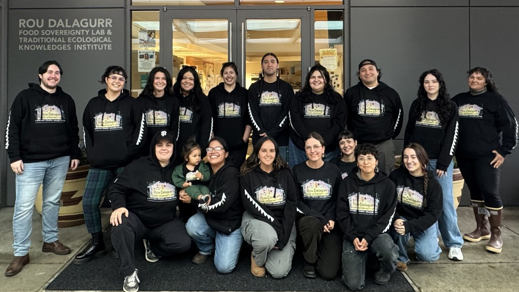 A large group of students in black sweatshirts in front of the Food Sovereignty Lab