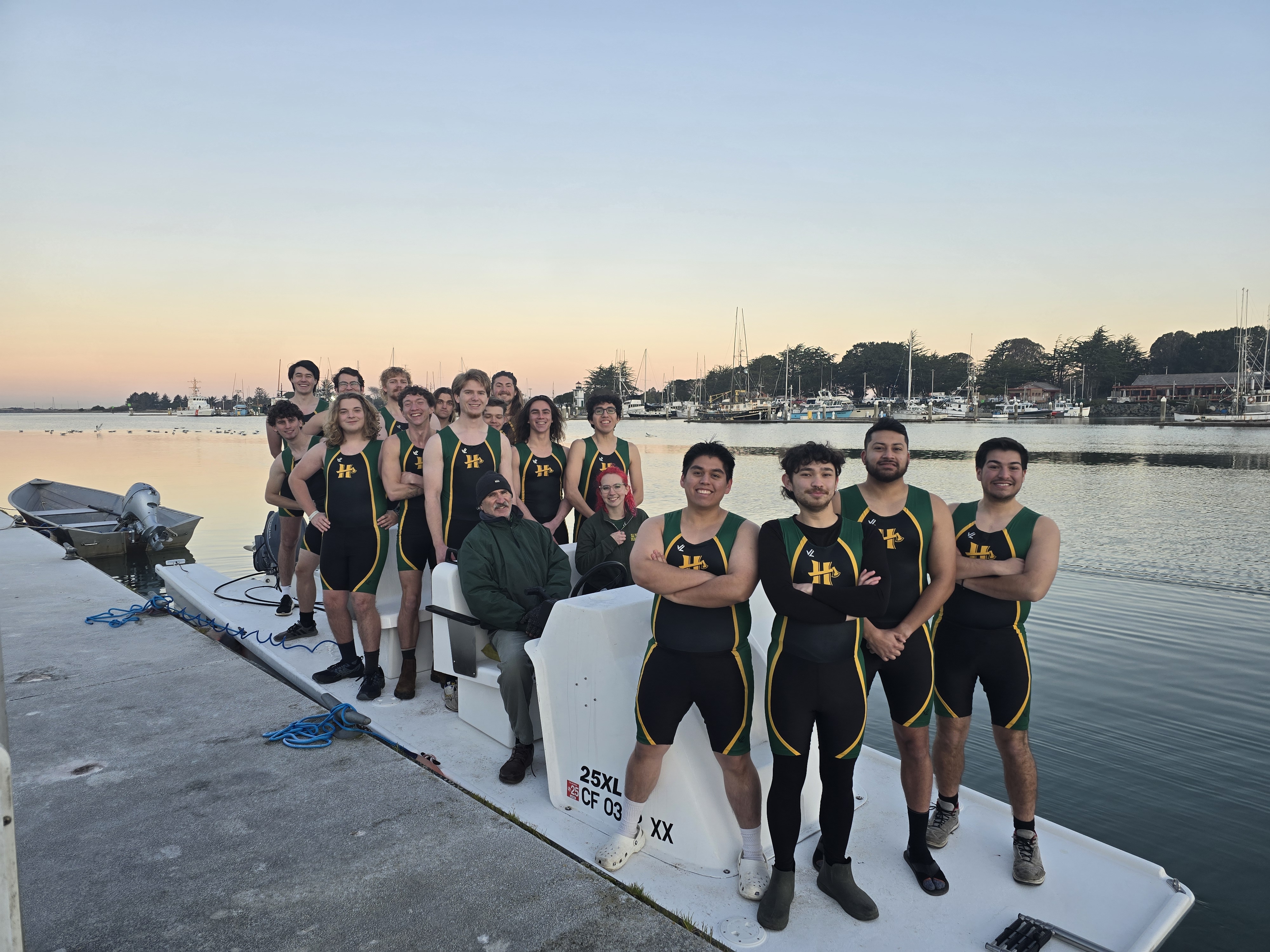 Men's crew club team standing on the dock.
