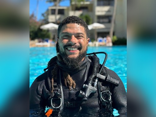 A photo of Kory Lamberts in a pool wearing scuba diving gear. 