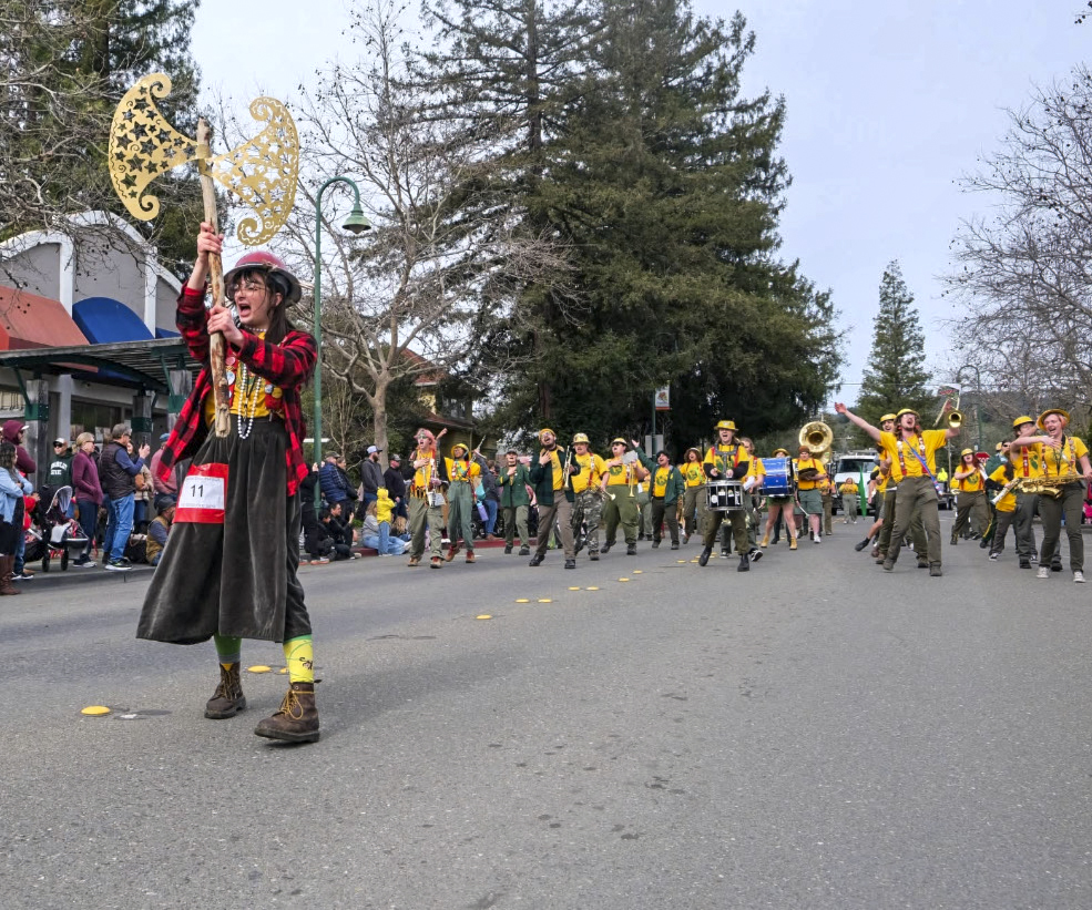 The Marching Lumberjacks and axe major marching in a parade.
