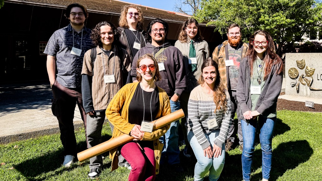 A group of math and data science students smiling on a green lawn.