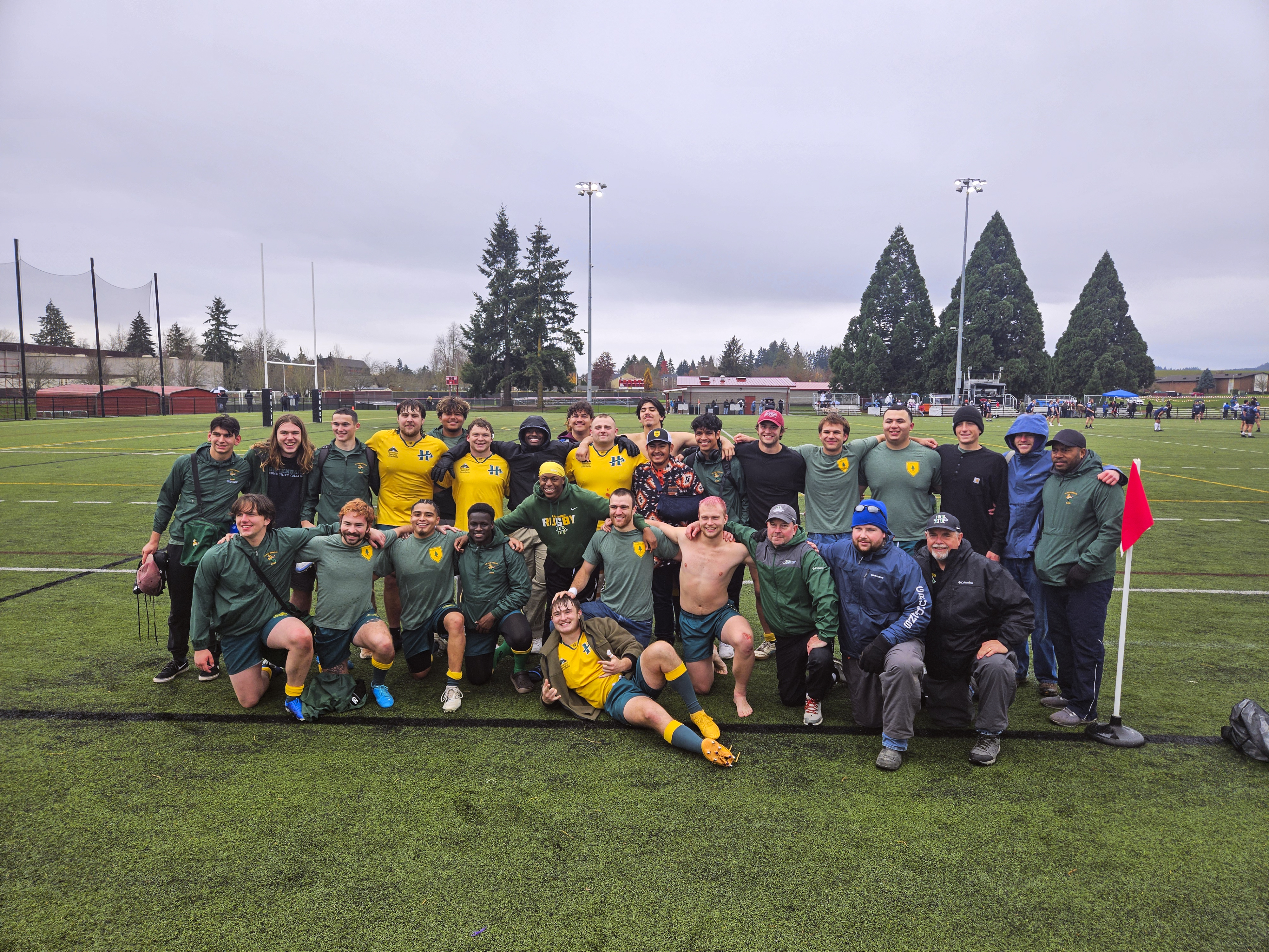 A rugby team photo after a game on the field.