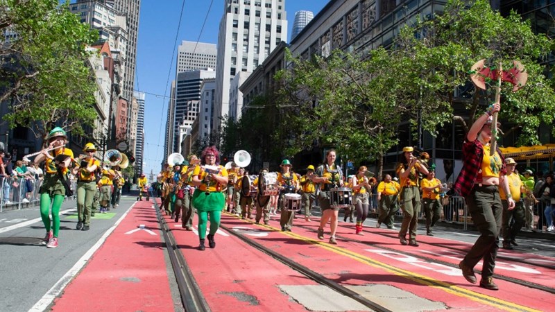 The Marching Lumberjacks band in a parade marching down a street.