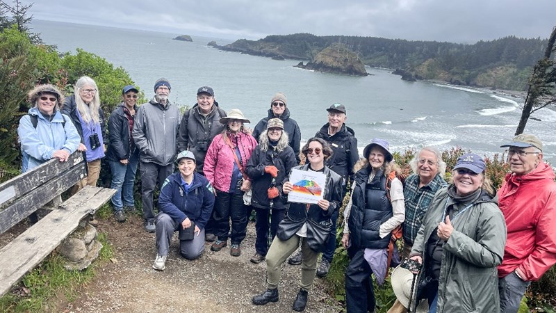 A group of OLLI members on a hike posed at an ocean look out.