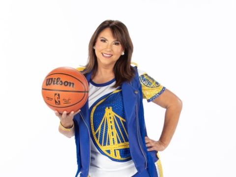 A photo of Liz Pimentel in her Golden State Warriors Hardwood Classics dance team uniform holding a basketball. 