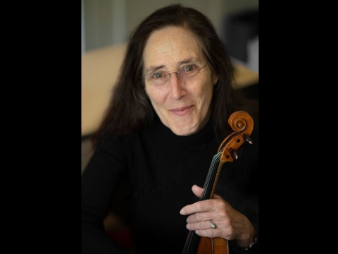 A photo of Carla Shapreau holding a violin. Photo by Max Thill