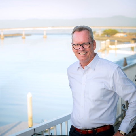 A photo of John Ballard with the Humboldt Bay in the background