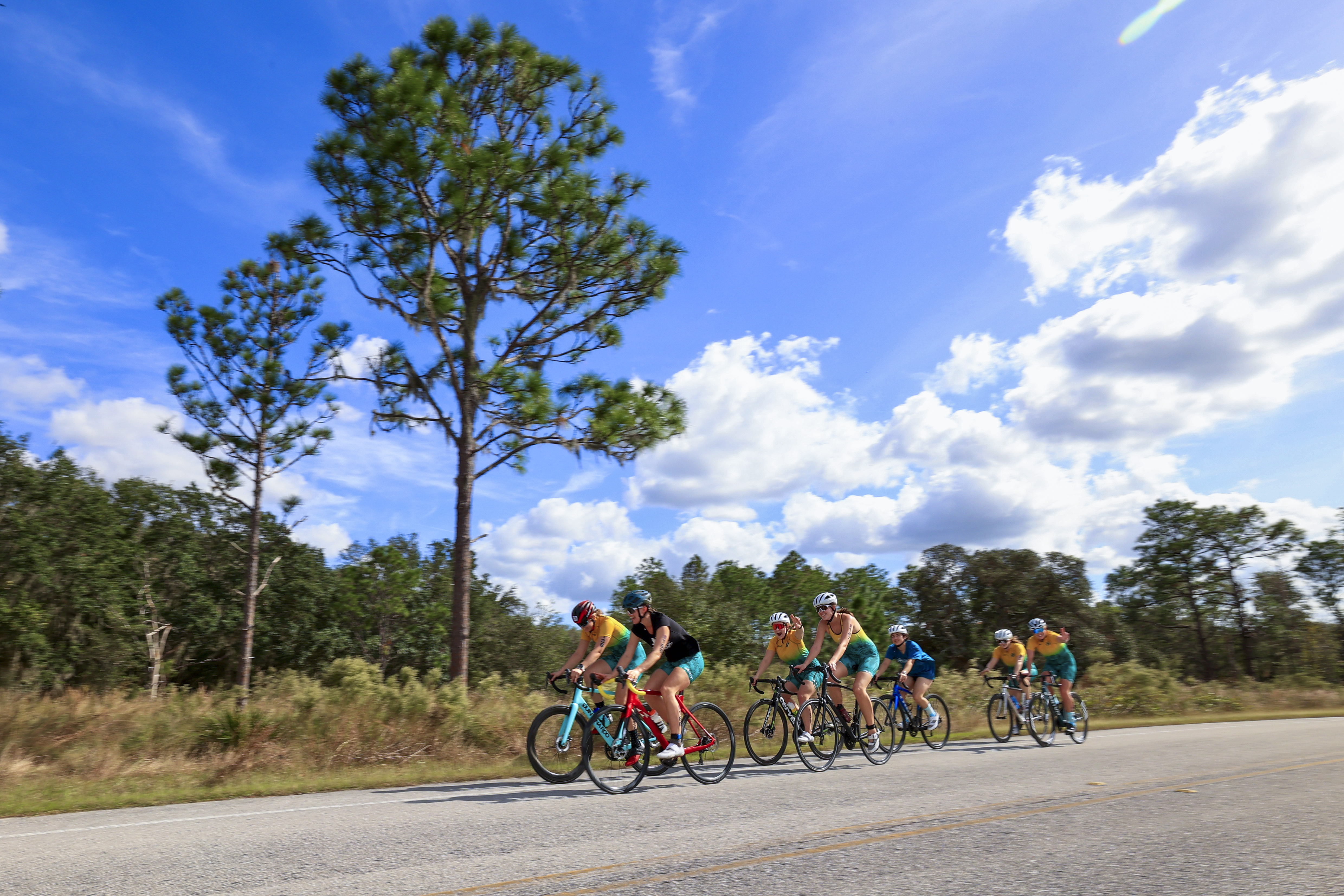 Seven women's triathlon athletes riding their bikes.